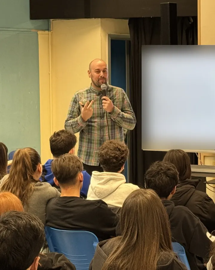 Hans Burtin speaking to a class of students