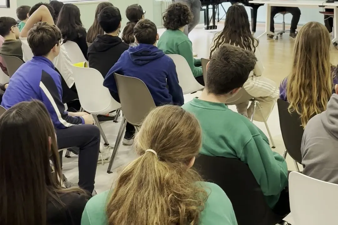 Students seen from behind, seated in a classroom during a session